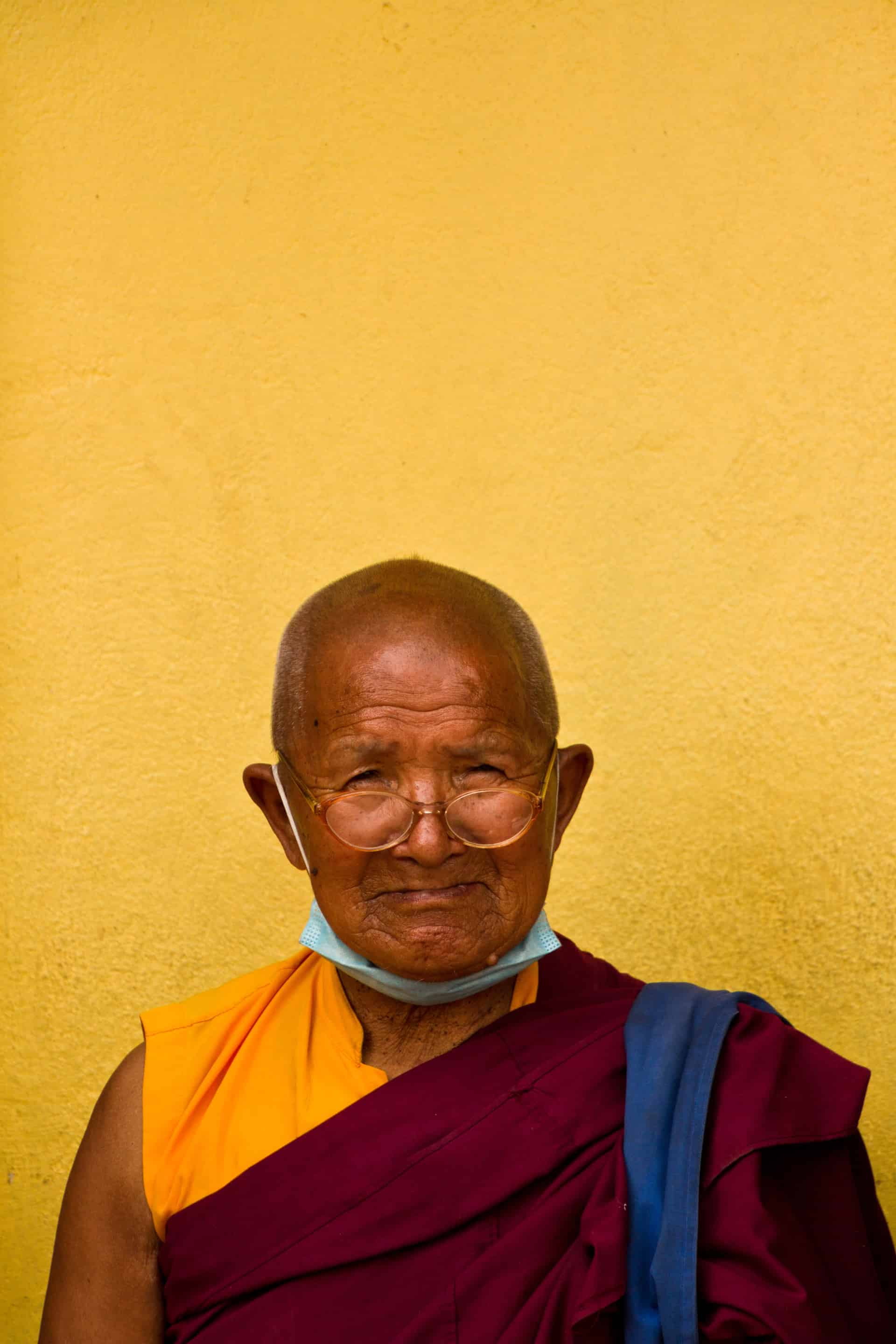 Elderly Tibetan Buddhist monk sits in the Boudhanath Temple grounds of Kathmandu, Nepal Boudhanath Temple, Kathmandu, Nepal
